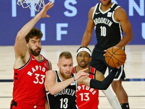 Dzanan Musa #13 of the Brooklyn Nets passes the ball while defended by Marc Gasol #33 of the Toronto Raptors during the second half in Game 3 of the first round of the NBA playoffs at The Field House at ESPN Wide World Of Sports Complex on Friday.