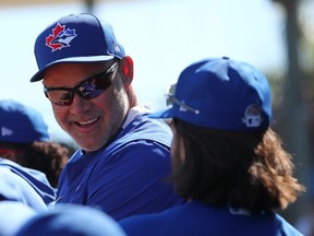 Toronto Blue Jays coach Dante Bichette talks with his son shortstop Bo Bichette (back to camera) in the dugout against the Pittsburgh Pirates during a spring training game.