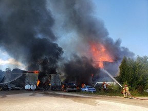 Firefighters battle a blaze Tuesday afternoon involving a century-old barn and maintenance shop on The Blue Mountains-Meaford Townline Road. SUPPLIED