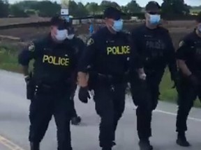 Police officers arriving in force to remove protesters at McKenzie Meadows in Caledonia Wednesday morning. (Facebook photo)