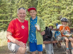 Dave Honeyman, Alpine Ski Coach and ACMG Summer Guide, stands with his son Kai and a cohort of local children taking a lunch break during his canadianrockiesalpine.com outdoor kids camp in Banff. photo by Pam Doyle/www.pamdoylephoto.com