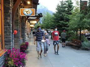 Visitors to Banff follow the mandatory mask bylaw on the main street pedestrian strip in August. Photo Marie Conboy.