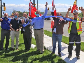 Municipal and provincial politicians, federal representatives and project team members celebrate after a ribbon-cutting ceremony to mark the completion of Phase One of the Bell Boulevard expansion Wednesday.
TIM MEEKS