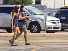 Shoppers wear masks as they head into a shopping mall in Brantford on Tuesday.