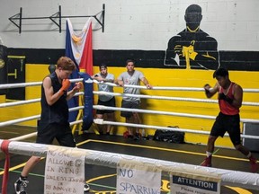 Owen Paquette (left) and Austine Bayani practise in the ring, while coaches Jordan Socholotiuk and Darryl Paquette look on at their new club, AFT Top Glove Boxing Academy Brantford.