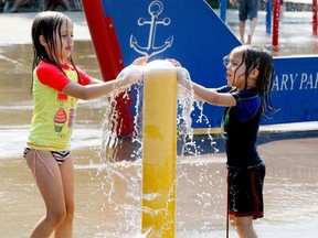 Maevry Couillard, left, 6, and her little brother Emeric, 4, who were down from Ottawa visiting family, cool off at Brockville's splash pad on a scorching Monday afternoon. (RONALD ZAJAC/The Recorder and Times)