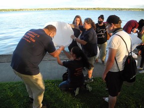 Members of Brockville's drug awareness team and mourners prepare to launch a lantern in memory of overdose victims. Wayne Lowrie/Recorder and Times