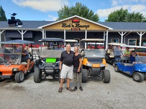 In this file photo from 2020, Dimitar Ljomov, left, chef at Bob 'n Buoys Bar and Boil, and restaurant manager Sherrie Dawson, are shown with golf cart owners at the Mitchell's Bay establishment. At the time, a petition was circulating in Mitchell's Bay calling on Chatham-Kent council to allow golf carts on local roads. During Monday's meeting, council voted in favour of lobbying the province for inclusion in a golf cart pilot project. (Handout)