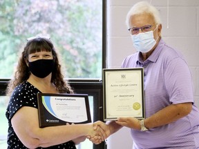 Active Lifestyle Centre executive director Linda Lucas, left, receives a certificate from Chatham-Kent-Leamington MPP Rick Nicholls marking the centre's 50th anniversary in Chatham, Ont., on Friday, Aug. 14, 2020. Mark Malone/Chatham Daily News/Postmedia Network