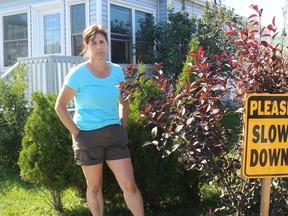Cornwall resident Lise Legault outside her house and beside one of the signs she's put up on her property, which has been damaged by vehicles on two occasions in the last three years. Photo on Friday, August 14, 2020, in Cornwall, Ont. Todd Hambleton/Cornwall Standard-Freeholder/Postmedia Network