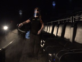 A masked employee at Landmark Cinemas cleans seats inside a theatre with a disinfectant called Vital Oxide. The Alberta government ordered movie theatres to close in mid-March 2020 when COVID-19 restrictions were first made. Movie theatres in Alberta were allowed to reopen on June 19, 2020. Supplied Image/Landmark Cinemas