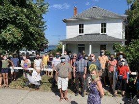 Wolfe Island Historical Society members stand outside the house they want to save from demolition at 1208 Main St. in Marysville on Friday. (Elliot Ferguson/The Whig-Standard)