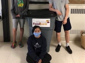Denise Pavao, left, and Zachary Wilson ran a food drive to support the Partners in Mission Food Bank. Some of their co-workers helped them put up flyers, including Rashy Abanag, middle. (Supplied Photo)