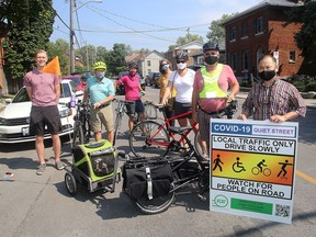 Members of the Kingston Coalition for Active Transportation, from left, Stephan Kukkonen, Roger Healey, Carla Teixeira, Kristin Cote, Janette Leroux, Bruce Bursey and his dog Oliver in the cart  and Brian T.F. Lee on Clergy Street at the corner of Queen Street in Kingston on Monday August 24, 2020.