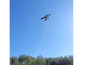 A water bomber passes over Highway 112 in Dane as it battles a fire near Round Lake Tuesday. The fire is now under control.