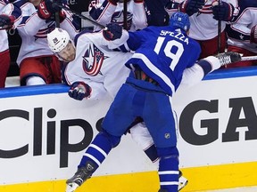 Leafs’ Jason Spezza (right) checks Columbus’ Oliver Bjorkstrand into the Blue Jackets bench during Game 5 of their series last night. Columbus won 3-0 to take the series. Getty Images