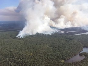 A Ministry of Natural Resources and Forestry water bomber in the foreground is dwarfed by a large plume of smoke behind it as fire crews continued to battle forest fires in the Temagami region in July 2018.
File Photo