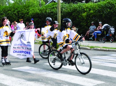 Members of the Nanton peewee Palominos hockey team wear their jerseys and carry their Central Alberta Hockey League championship banner during the Round-Up Days parade Aug. 3.
