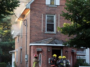 Smoke could be seen coming from an upstairs window of this Mary Street home, shortly after the fire broke out around 7:30 p.m. Thursday night as members of the Pembroke Fire Department prepare to enter the building. The fire was quickly contained, but five people have been displaced.