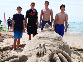 Burlington friends (from left to right) Cameron Smith, 18, Gavin Freitag, 17, Kevin Lin, 18, and Blair Chadwick, 18, stand with their hermit crab sand sculpture at Sauble Sandfest at about 1 p.m. Saturday. Competitors could build from 9 a.m. until judging time at 3 p.m. DENIS LANGLOIS