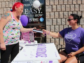 Sarnia resident Melissa Thomas receives a naloxone kit from Amy Polkinghorne, a registered pharmacy technician, during an International Overdose Awareness Day event at BMC Pharmacy on Monday August 31, 2020 in Sarnia, Ont. (Terry Bridge/Sarnia Observer)