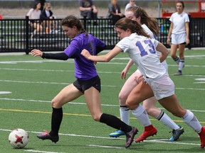 Kristen Mrozewski, left, of the Lo-Ellen Knights, runs past  Cassidy Burton and Kaitlyn Chevrier, of the Marymount Regals, during girls high school soccer semifinal action at James Jerome Sports Complex in Sudbury, Ont. on Friday May 24, 2019. Some worry that due to the pandemic, sports will lose a generation of female athletes. John Lappa/Sudbury Star/Postmedia Network
