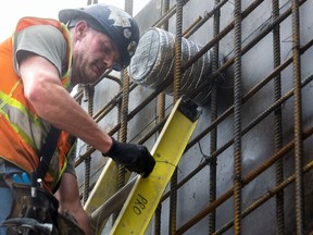 Joe Valeriote of Pro Electric wires a pipe sleeve into place before a cement wall is poured at the site of the former Alma College in St. Thomas. Three apartment buildings will be built by Sierra General Contracting at the site over five years. (Mike Hensen/Postmedia Network)