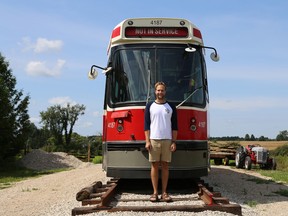 Alex Glista, 24, with his decommissioned Toronto Transit Commission streetcar (No. 4187) at his family's farm in Priceville. Glista purchased the streetcar from the TTC in an online auction for $3,400 in June and has since hauled it to the the farm and placed it on a track he built with the help of his father and a few neighbours. Greg Cowan/The Sun Times