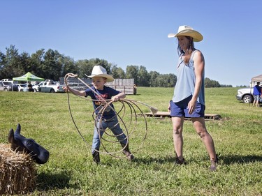 Jill Byers who owns Blue Ridge Farms with her husband gave little cowboy Easton Moore a demo on how to rope a cow bale. Byers opened her farm up to visitors to tour it as part of Alberta's Open Farm Days. 
Brigette Moore