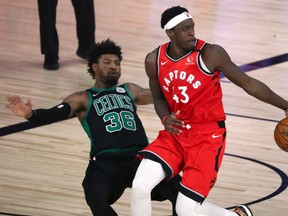 Raptors forward Pascal Siakam is defended by Celtics guard Marcus Smart during Monday night’s game.