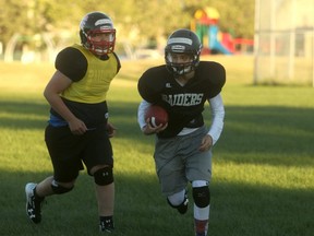 Grande Prairie Raiders quarterback Madex Rutherford carries the ball during fall camp action at Alexander Forbes School on Monday night while lineman Alex Scott looks on. The Raiders will open a modified football schedule when they play the Grande Prairie Broncos at CKC Field on Sept. 9.
