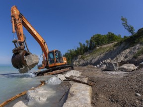 Cody Rahn of Huron District Contracting moves a boulder that will form part of a barrier against record-high water levels on the shoreline of Lake Huron just north of Bayfield on Sept. 1. Mike Hensen/Postmedia Network