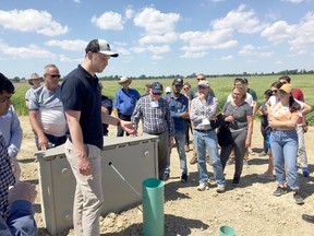 Colin Little (in the front), from the Lower Thames Valley Conservation Authority, explains how the phosphorus capturing water tank at the Roesh farm works to a group of people on June 26, 2019. JAKE ROMPHF Postmedia Network