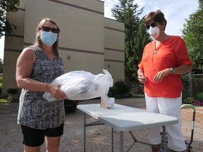 Cheryl Mader, left, drops off a bundle of her art for Diane Roberts, Oxford Creative Connections Inc. volunteer, for inclusion in the Sept. 8-Nov. 4 Small Wonders, Big Talent art show at Annandale National Historic Site in Tillsonburg. (Chris Abbott/Postmedia Network)