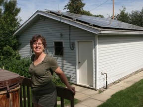 Joan Blench, Peace River, poses with her new 6.4-kilowatt roof-mounted solar array that will reduce her electrical bills by about 70 per cent. This is the first solar array designed and installed by Peace Energy Cooperative in the Town of Peace River, Alta.