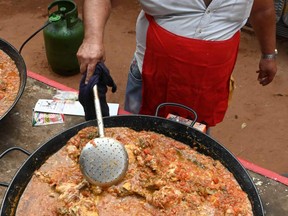 A volunteer cooks for people in need in Asuncion, Paraguay over the weekend. The novel coronavirus has killed at least 910,300 worldwide, including almost 500 in Paraguay, since the outbreak emerged in China last December. NORBERTO DUARTE/AFP via Getty Images