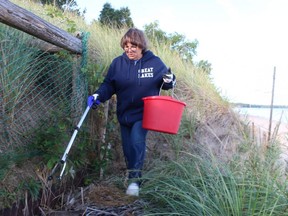 Sandra Marshall collects trash during Saturday's shoreline cleanup on Ipperwash Beach.