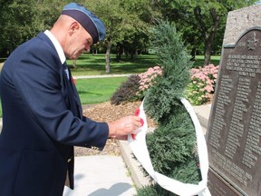 Doug Janson pins a poppy at a memorial in Sarnia's Germain Park Sunday for the 80th anniversary of the Battle of Britain.