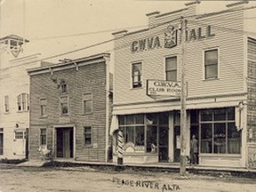 87.1489.12  Waldref Hall, where Mary Young and many others enjoyed a break from everyday trials and tribulations in the renovated building between the first Fire Hall and the Great War Veterans Association building. At one time, Winn Waldref, in addition to the hall, conducted businesses on the ground floor of the GWVA  haberdashery, and for those seeking tonsorial services, a barber shop and beauty parlour. Note wooden sidewalks, only beginning to be replaced in 1932.