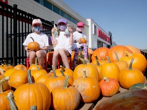 Payton Ens, centre, with her cousins Grace (left) and Hazel Kamenar and family were selling pumpkins at Canadian Tire in Tillsonburg on the weekend, raising funds for Childcan. (Chris Abbott/Norfolk Tillsonburg News)