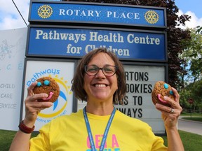 Marcy Draker, with Pathways Health Centre for Children in Sarnia, gives some Tim Hortons Smile Cookies a run for their money. Sales of the cookies at Tim Hortons locations in Sarnia in September will help support Pathways.