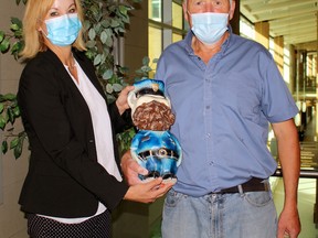 Tammy Morison, president and CEO of the North Bay Regional Health Centre Foundation, and Mark Montgomery hold the piggy bank Montgomery has been filling since 2008. The bank coughed up $928.01 for the hospital foundation when it was opened Monday morning.
PJ Wilson/The Nugget