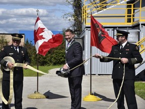 Woodstock mayor Trevor Birtch cuts a ceremonial fire hose with the fire department’s extrication tools to mark the official opening of the Woodstock Fire Department’s live fire training centre on Friday, September 18, 2020. Pictured, Birtch with deputy fire chief Trevor Shea (left) and fire chief Jeff Slager (right). (Kathleen Saylors/Woodstock Sentinel-Review)