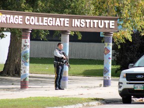 An officer at the south entrance to Portage Collegiate Institute after a threat was made against the school this morning. (Aaron Wilgosh/Postmedia)