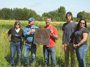Blenheim-area farmers Jim Rodger (blue shirt) and son Gary Rodger (red shirt) accept the Sydenham Field Naturalists' Friends of Nature Award on Sept. 13 at their property. From left are Janet, Jim, Gary, Daniel and Tina Rodger. Submitted