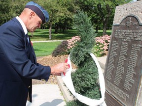 Doug Janson pins a poppy at a memorial in Sarnia's Germain Park Sunday for the 80th anniversary of the Battle of Britain. Paul Morden/Postmedia Network