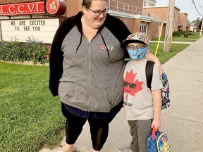 Celine Gaudreau waits with son Simon at a bus stop near Lambton Central Collegiate and Vocational School on Sept. 14 in Petrolia. Terry Bridge/Postmedia Network