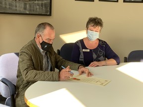 Portage la Prairie Mayor, Irvine Ferris, and North Central Regional Coordinator for the Alzheimer Society of Manitoba, Donna Frost taking part in the proclamation signing at city hall last week. (Aaron Wilgosh/Postmedia)