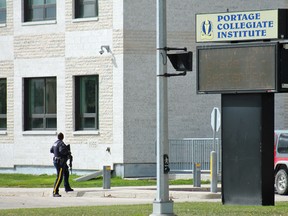 An officer at the parking lot entrance to Portage Collegiate Institute in Portage la Priarie. (Aaron Wilgosh/Postmedia)