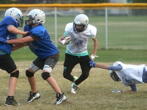 Grande Prairie Norsemen runner Ryker Geherman lugs the ball while teammate Tristan Chalifoux stretches full out for an attempted tackle. Koen Hanson and Ben Little provide the blocking on the play during a Tuesday night drill at the Norsemen’s practice field across from Grande Prairie Composite. The club opened the nine-man season last weekend and learned plenty about the game and the way they need to play to be successful.
